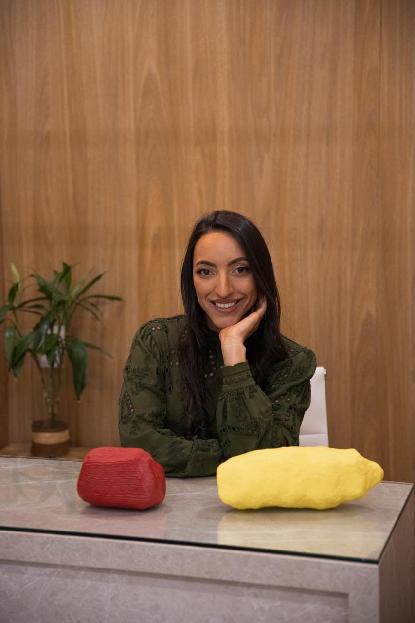 Talita Rodrigues sorrindo em ambiente de atendimento
